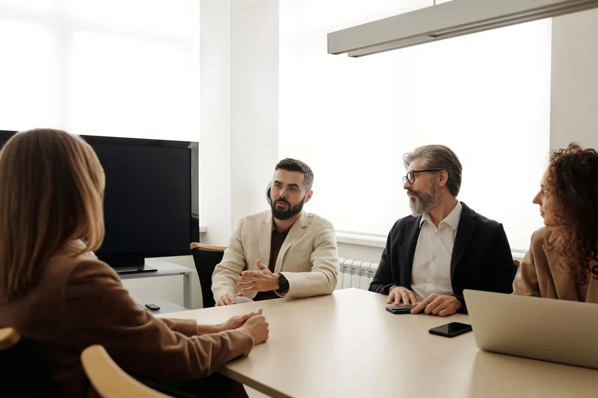 Beratungsgespräch an einem Besprechungstisch mit mehreren Gesprächspartnern